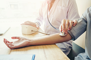 Person using an at home blood pressure monitor.