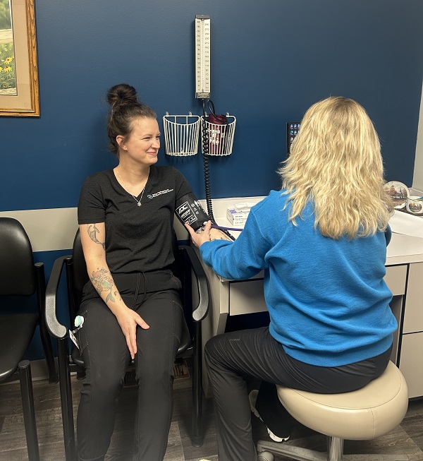 A nurse at VPCHC taking another nurse's blood pressure.