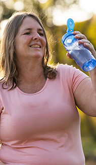 Woman taking a water break during her walk.