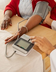 Close up of professional nurse checking blood pressure for woman